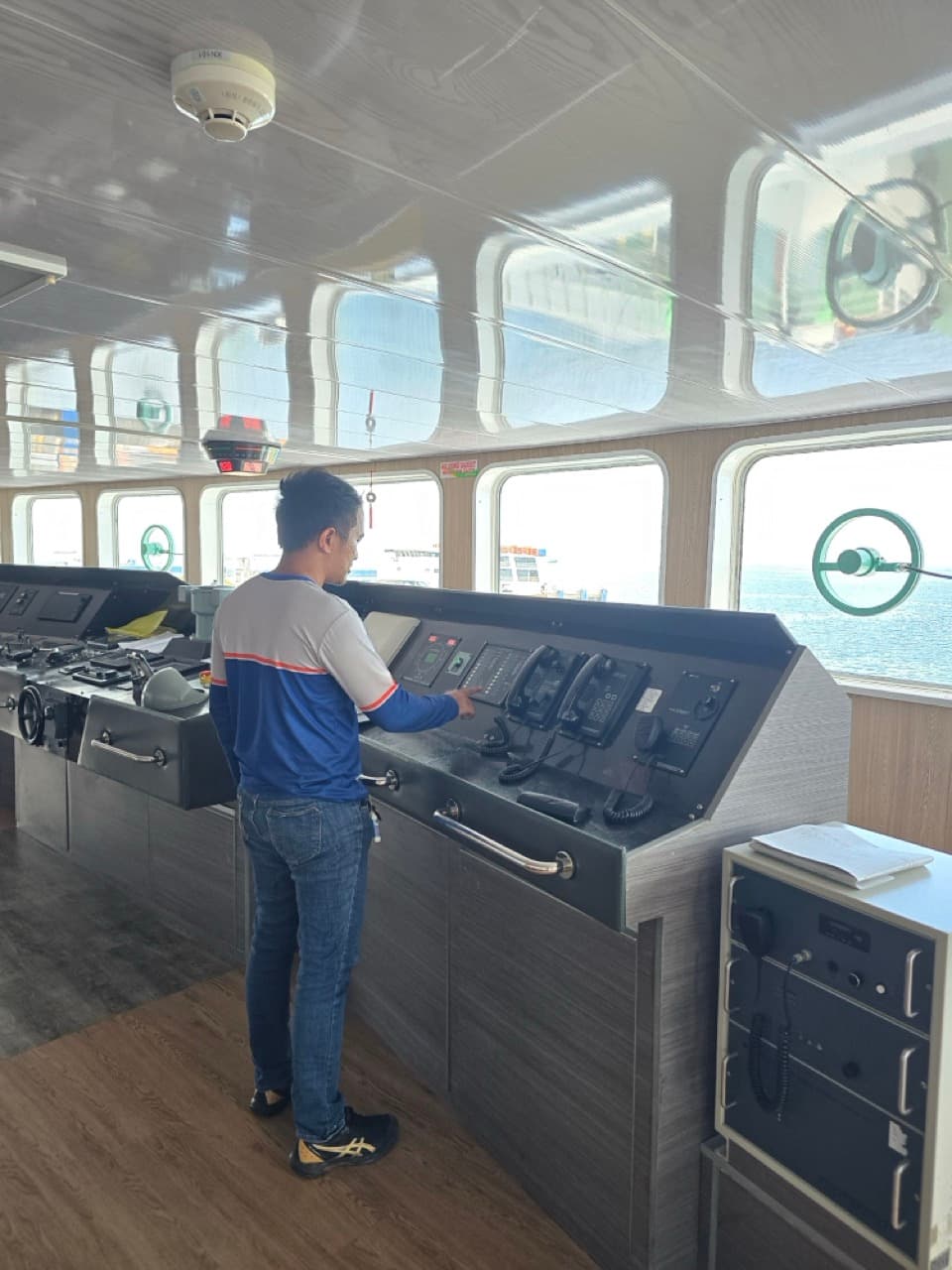 Technicians working on a ship bridge control console